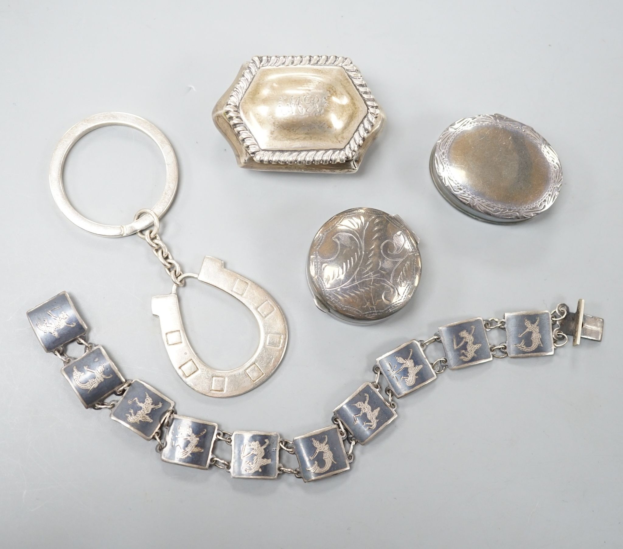 Three silver pill boxes, a key ring and white metal and niello bracelet.